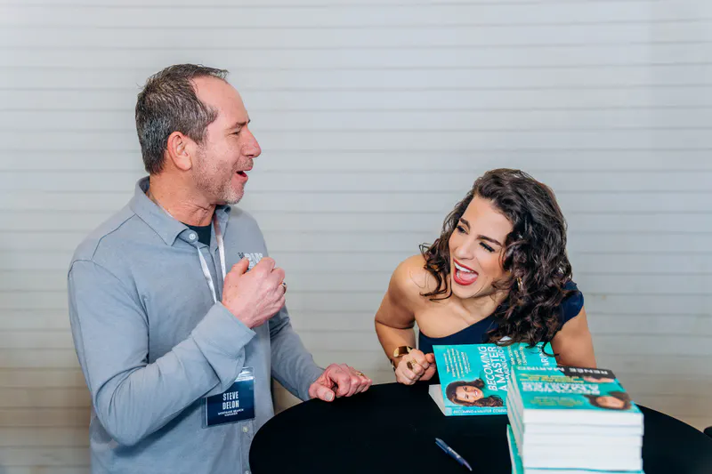 Renée Marino in conversation with a reader across a signing table