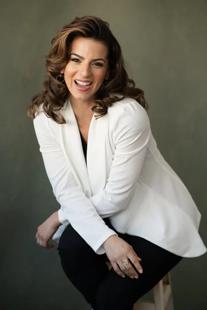 Renée Marino smiling in a white blazer
