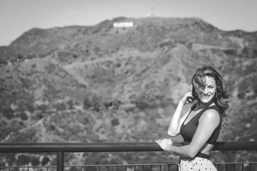 Renée Marino smiling beneath the Hollywood sign